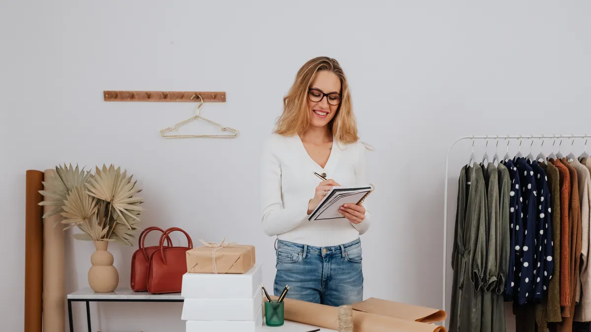 Retail worker with tablet and clothing inventory