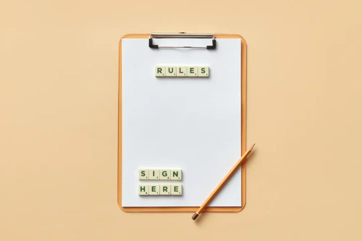 Clipboard with rules and sign here labels