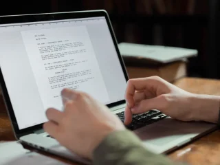hands typing a document on a laptop
