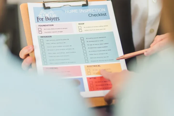 Hand holding a buyer's checklist clipboard