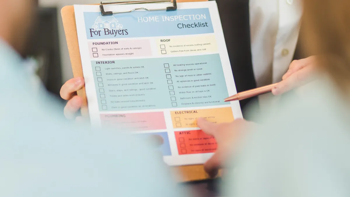 Hand holding a buyer's checklist clipboard