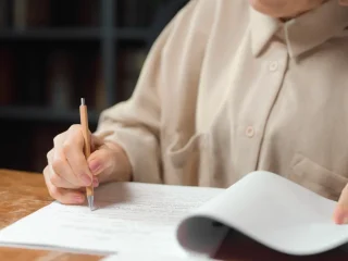 person proofreading a printed document at a desk