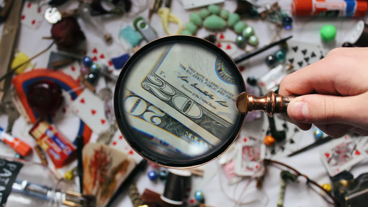 Magnifying glass over cash and scattered items
